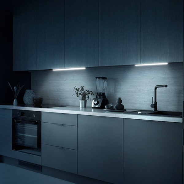 Modern kitchen illuminated by a magnetic rechargeable infrared lamp under cabinets.